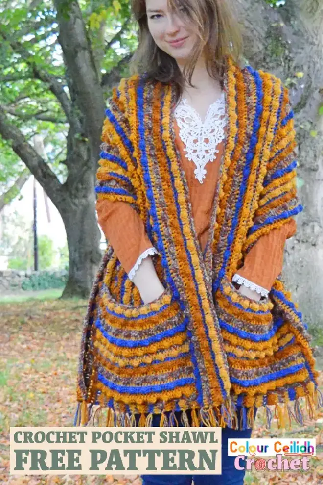 This crochet pocket shawl is called Autumn Berries and it is an easy breezy pattern with the tassel fringe made using the yarn tails from the color change. Featuring a generous size and a simple repeat of 5 colors, this relaxed style shawl is beginner friendly and is great for romantic walks in nature to snuggle yourself into. Includes a tassel fringe photo tutorial and custom fit sizes, such as plus sizes. #crochetpocketshawl #crochet #pocketshawl